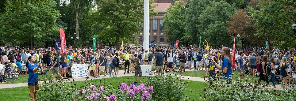 Students gather on a large lawn on campus for an Activities fair